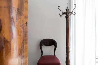 a chair sitting next to a window next to a lamp at Nobile Casa St.Maria in Rome