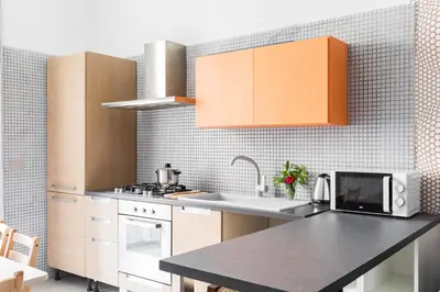 a kitchen with orange cabinets and a counter top at Nobile Casa St.Maria in Rome
