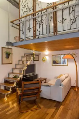 a living room with a couch and a staircase at Loft in Testaccio in Rome