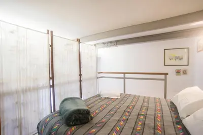 a bedroom with a bed with a green pillow on it at Loft in Testaccio in Rome