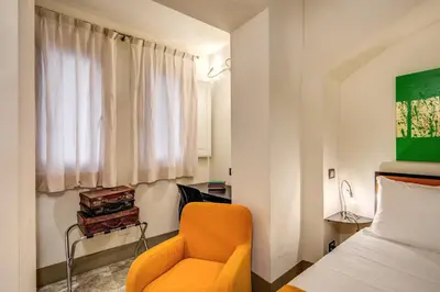 a bedroom with an orange chair and a bed at Argileto Terra in Rome