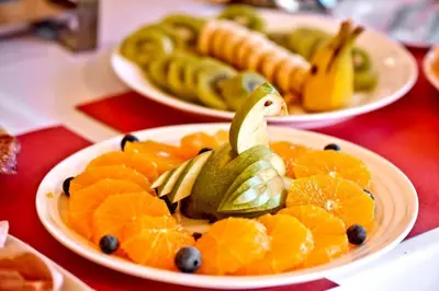 three plates of fruit on a red table at Argileto Terra in Rome