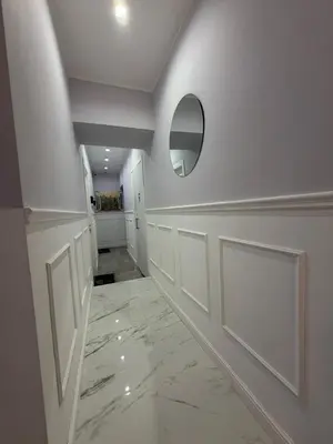 a hallway with white walls and a mirror and marble floor at IHH COLLECTION - Eden Luxury Roma in Rome