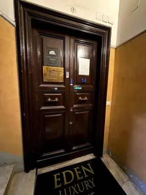 a wooden door in a building with a sign on it at IHH COLLECTION - Eden Luxury Roma in Rome