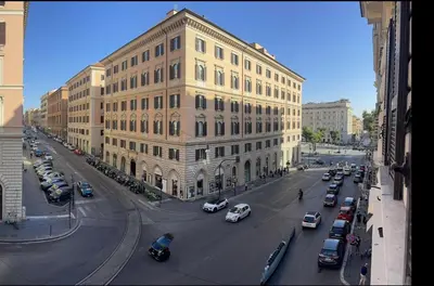 a large building with cars parked in front of a street at IHH COLLECTION - Eden Luxury Roma in Rome