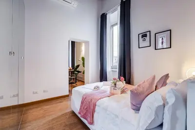 a white room with a bed and a window at Klioos Apartment in Rome