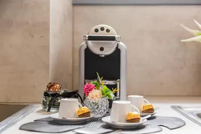 a table with plates of food and a coffee maker at Klioos Apartment in Rome