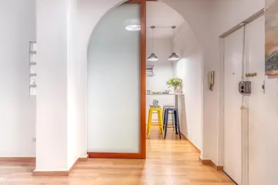 a hallway with an arched door and a table at Relais Mantellini in Rome