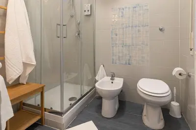 a bathroom with a shower and a toilet and a sink at Relais Mantellini in Rome