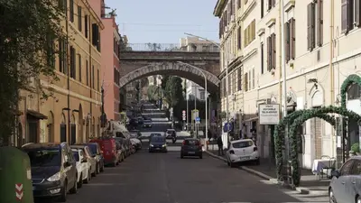 a city street with a bridge and cars parked at A un passo dal centro in Rome