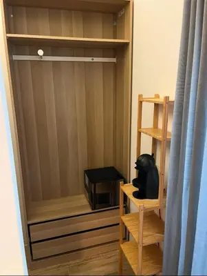 a room with a wooden closet with a black object on a shelf at A un passo dal centro in Rome