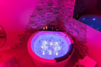 a bathroom with a tub in a pink room at Silver Suite Coliseum in Rome