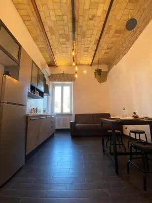 a kitchen and living room with a couch and a table at Basilica Papale di San Paolo Appartamento Moderno - YOURhOME in Rome