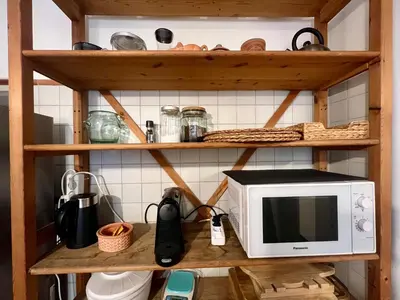 a kitchen with a microwave on a wooden shelf at Casa Pinturicchio in Rome