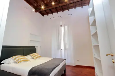 a bedroom with a bed with white walls and shelves at Campo dei Fiori Giubbonari Amazing in Rome
