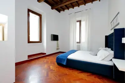 a bedroom with a bed and a desk and two windows at Campo dei Fiori Giubbonari Amazing in Rome