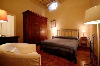 a bedroom with a bed and a chair in it at Family 2BR Apartment in Via Giulia in Rome