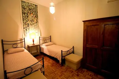 a small room with two beds and a dresser at Family 2BR Apartment in Via Giulia in Rome