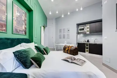 a bedroom with a white bed with green walls at Luxury Trevi Fountain - Your Italian Holidays in Rome