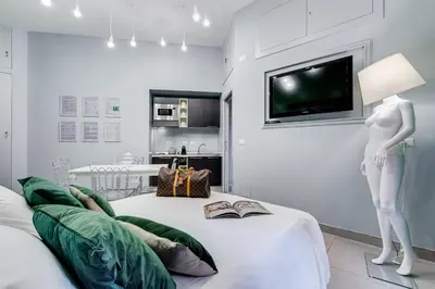 a mannequin standing on a bed with a tv on a wall at Luxury Trevi Fountain - Your Italian Holidays in Rome