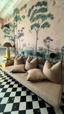 a couch with pillows in a room with a wall mural at Casa Morgana - The Pantheon Balcony Suite in Rome