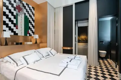 a bedroom with a large white bed and a bathroom at Casa Morgana - The Pantheon Balcony Suite in Rome