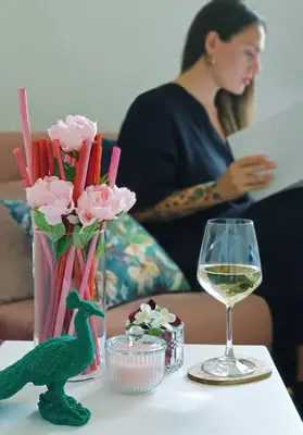 a table with a vase of flowers and a glass of wine at Glory House Trastevere in Rome