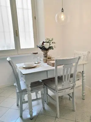 a white dining room table and chairs with a white table and chairsktop at Glory House Trastevere in Rome