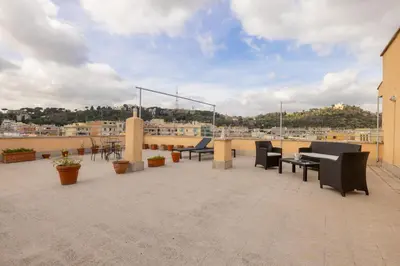 a patio with chairs and tables on a roof at Top Floor Apt with Rooftop Terrace near St. Peter in Rome
