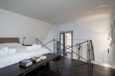a bedroom with a bed and a table with books at Rome Loft in Rome
