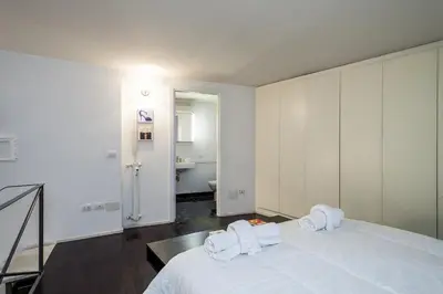 a white bedroom with a large bed with towels on it at Rome Loft in Rome
