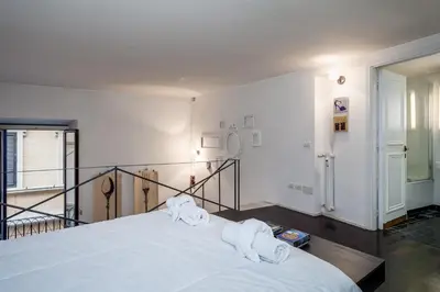 a bedroom with a large white bed with towels on it at Rome Loft in Rome