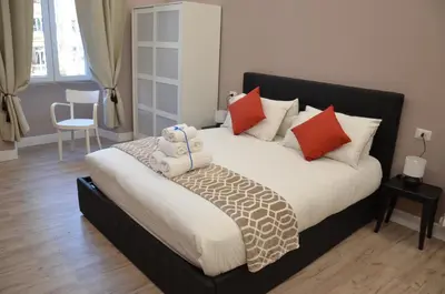 a bedroom with a large bed with red and white pillows at San Peter Vale House in Rome