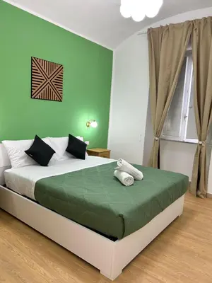a bedroom with a bed with a green wall at San Peter Vale House in Rome