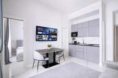 a white kitchen with a table and two chairs at Rome Deluxe Apartments in Rome