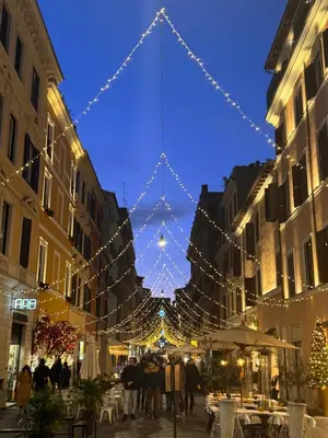 a group of people walking down a street with christmas lights at Rome Deluxe Apartments in Rome
