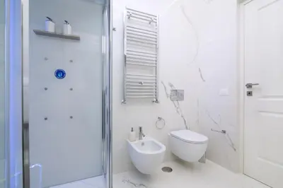 a white bathroom with a toilet and a shower at Rome Deluxe Apartments in Rome