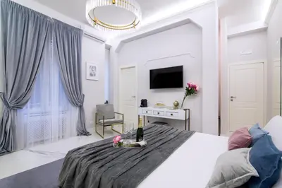 a white bedroom with a bed with flowers on it at Rome Deluxe Apartments in Rome