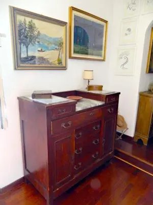 a wooden dresser in a room with paintings on the wall at Abitazione Pigneto B&B in Rome