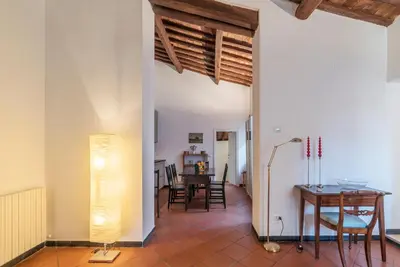 a living room with a table and chairs and a lamp at Three bedrooms in world-famous Via Giulia - FromHometoRome in Rome