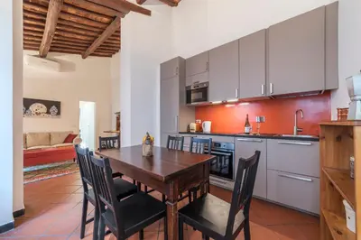 a kitchen and dining room with a wooden table and chairs at Three bedrooms in world-famous Via Giulia - FromHometoRome in Rome