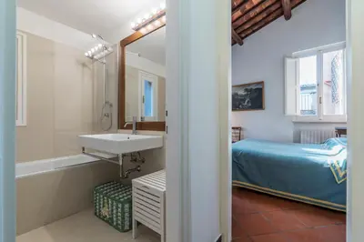 a bathroom with a sink and a bed and a tub at Three bedrooms in world-famous Via Giulia - FromHometoRome in Rome