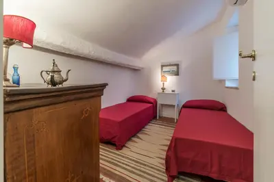a small room with two beds and a table at Three bedrooms in world-famous Via Giulia - FromHometoRome in Rome