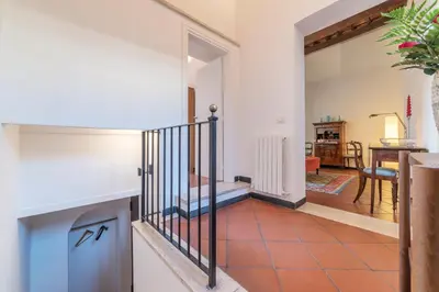 a living room with a staircase and a fireplace at Three bedrooms in world-famous Via Giulia - FromHometoRome in Rome