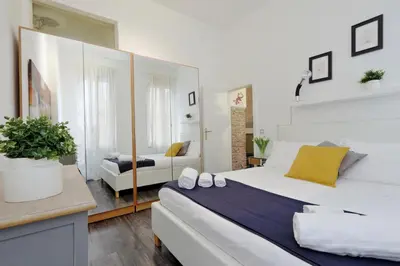 a bedroom with a large white bed and a couch at Urbana Delicious Flat in Rome