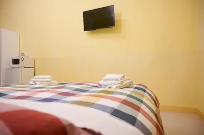 a room with a bed with a tv on the wall at On The Rainbow B&B in Rome