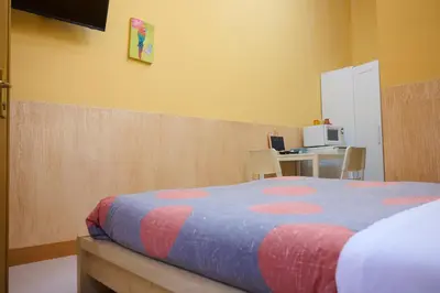 a bedroom with a bed and a desk with a microwave at On The Rainbow B&B in Rome