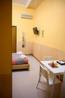 a room with a bed and a table and a desk at On The Rainbow B&B in Rome