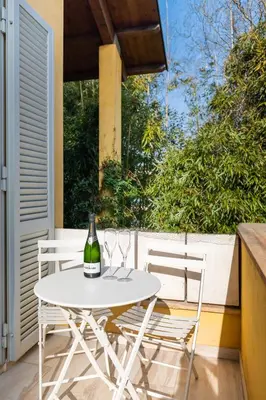 a white table with two chairs and a bottle of wine at Relais Clivo Vaticano in Rome