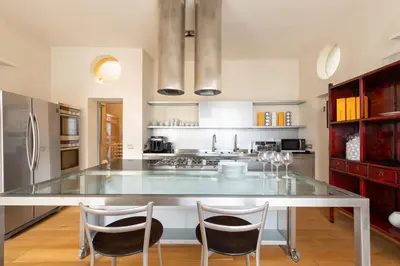 a kitchen with a large glass table and two chairs at Relais Clivo Vaticano in Rome